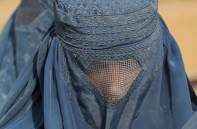 Uma mulher afegã espera na fila para receber suprimentos de inverno em um centro de distribuição do ACNUR para refugiados carentes nos arredores de Cabul. Uma mulher afegã espera na fila para receber suprimentos de inverno em um centro de distribuição do ACNUR para refugiados carentes nos arredores de Cabul.