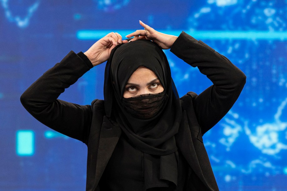 Thamina Usmani, cobre o rosto durante uma transmissão ao vivo na estação de TV Tolo em Cabul, Afeganistão, em 22 de maio de 2022.