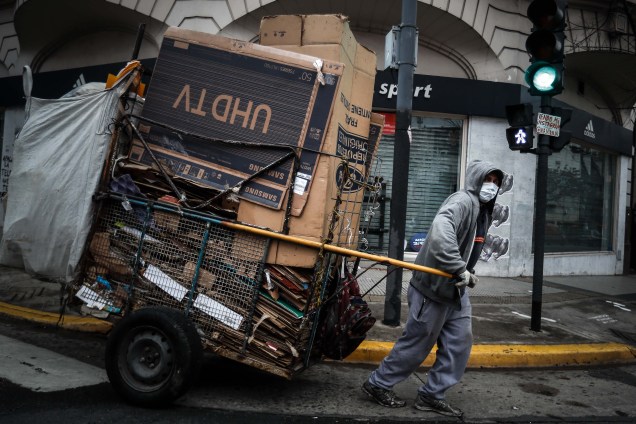 Um homem recolhendo papelão nas ruas de Buenos Aires para reciclagem.