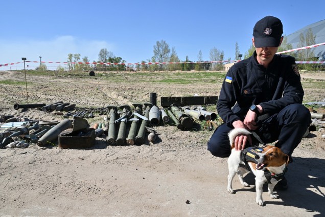 Treinador e seu cão farejador de bombas, mascote do Serviço de Situações de Emergência da Ucrânia em Hostomel, na região de Kiev, em 5 de maio de 2022.