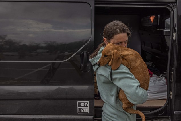 Mulher com seu cachorro após chegar da área ocupada pelos russos no sul da Ucrânia ao ponto de evacuação em Zaporizhzhia, Ucrânia, 02 de maio de 2022.