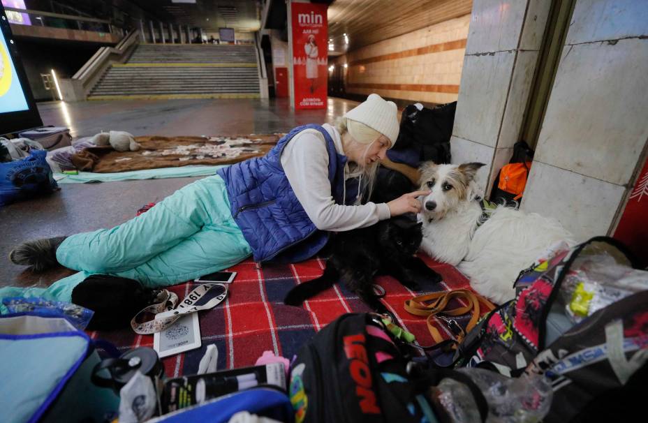 Uma mulher e seu cachorro se abrigam em uma estação de metrô em Kiev, Ucrânia, 02 de março de 2022.