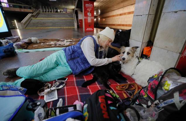 Uma mulher e seu cachorro se abrigam em uma estação de metrô em Kiev, Ucrânia, 02 de março de 2022. Uma mulher e seu cachorro se abrigam em uma estação de metrô em Kiev, Ucrânia, 02 de março de 2022.