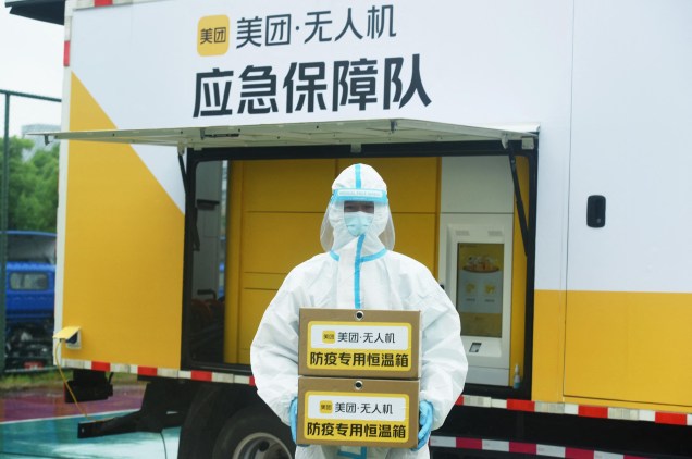 Um funcionário do sistema de saúde local com caixas contendo amostras, deixadas por um drone de entregas, testes para o Coronavírus Covid-19, em Hangzhou, na província de Zhejiang, 24/05/2022.
