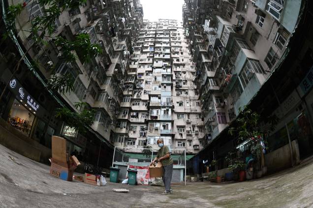 Foto tirada em 22 de março de 2022, mostra uma mulher coletando papelão em um conjunto habitacional em Hong Kong.