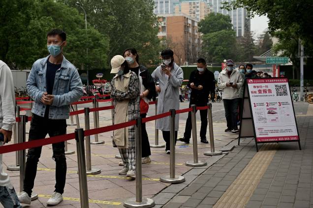 Pessoas em fila para fazer teste do Coronavírus Covid-19 em um local de coleta, em Pequim em 10 de maio de 2022.