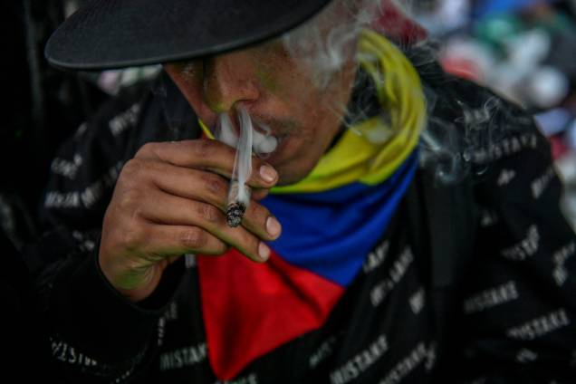 Um homem fuma um cigarro de Maconha, durante a Marcha Global da Maconha exigindo a legalização, em Medellín, região de Antioquia, Colômbia, em 7 de maio de 2022.
