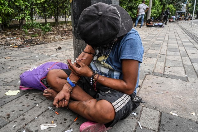 Um viciado em drogas se injeta heroína no centro de Medellín, Colômbia, em 19 de março de 2022.