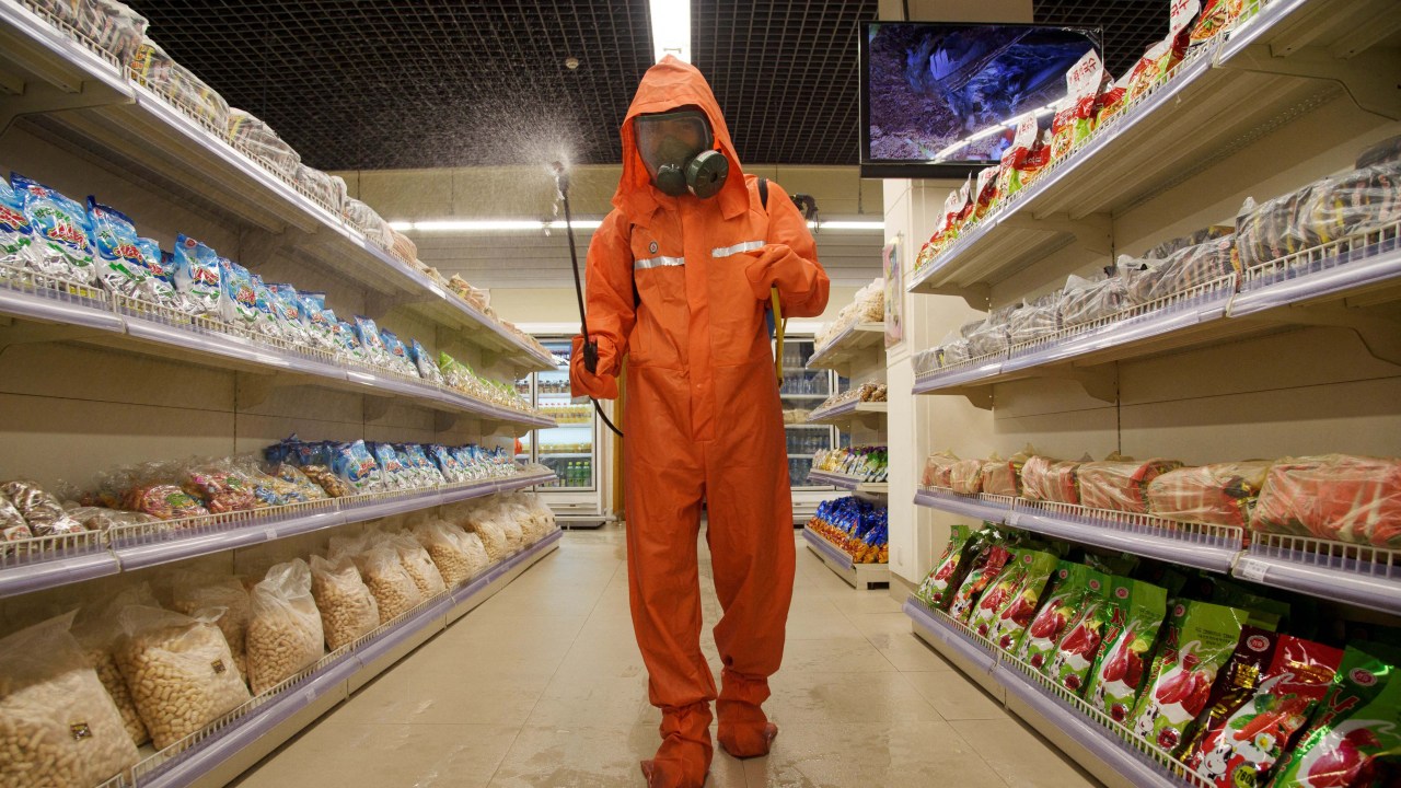 (FILES) In this file picture taken on September 27, 2021, a health official sprays disinfectant as part of preventative measures against Covid-19, in the Daesong Department Store in Pyongyang. - North Korea on May 12, 2022 confirmed its first-ever case of Covid-19, with state media declaring it a "severe national emergency incident" after more than two years of purportedly keeping the pandemic at bay. (Photo by KIM Won Jin / AFP)