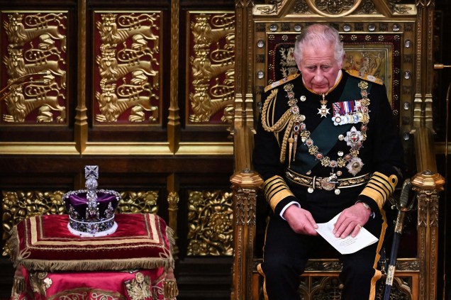 O príncipe britânico Charles, Príncipe de Gales, sentado ao lado da Coroa do Estado Imperial, após ler o discurso da Rainha Elizabeth, na Câmara dos Lordes, durante a Abertura Estadual do Parlamento, em Londres, em 10 de maio de 2022.