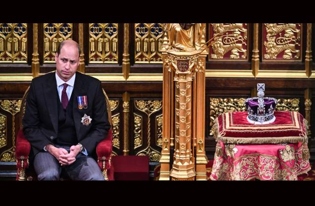 O príncipe britânico William, Duque de Cambridge, sentado ao lado da Coroa do Estado Imperial, na Câmara dos Lordes, durante a Abertura do Parlamento, em Londres, em 10 de maio de 2022.