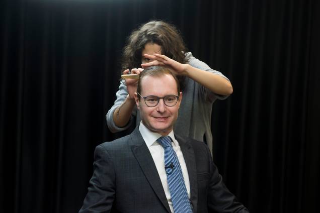 A maquiadora fazendo os ajustes finais antes da entrevista com os jornalistas -