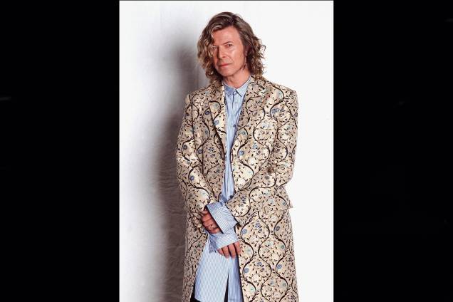 Cantor e músico inglês David Bowie, posa para fotos nos bastidores do Glastonbury Festival em Somerset, Inglaterra com um casaco desenhado por Alexander McQueen, em 25/06/2000.