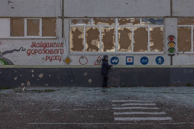 Oleksandr Gumenchak, funcionário do Serviço de Emergência do Estado da Ucrânia, verifica a área próxima a uma escola em busca de explosivos depois de ter sido atingida pelo bombardeio russo, nos arredores de Kharkiv, nordeste Ucrânia, 15 de abril de 2022.  A segunda maior cidade da Ucrânia e seus arredores foram fortemente bombardeados pelas forças russas, com muitos civis mortos, desde que a invasão militar russa da Ucrânia começou em 24 de fevereiro de 2022.