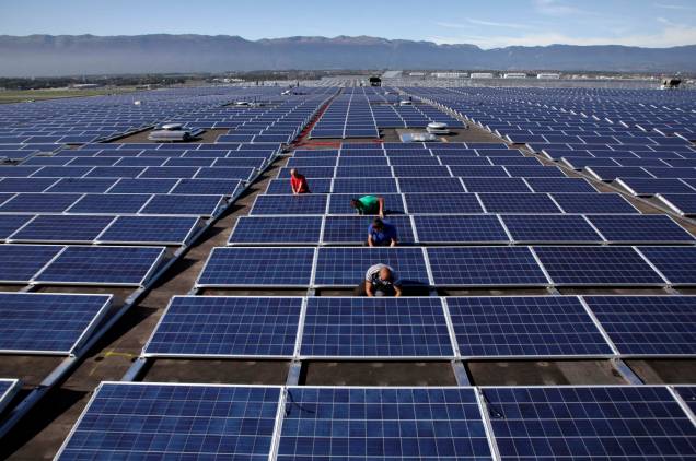 Trabalhadores instalando painéis solares no telhado do Centro de Exposições Palexpo em Genebra, O Partido Verde Suíço apresentou sua estratégia para a eliminação da energia nuclear e para uma reviravolta de energia sustentável.