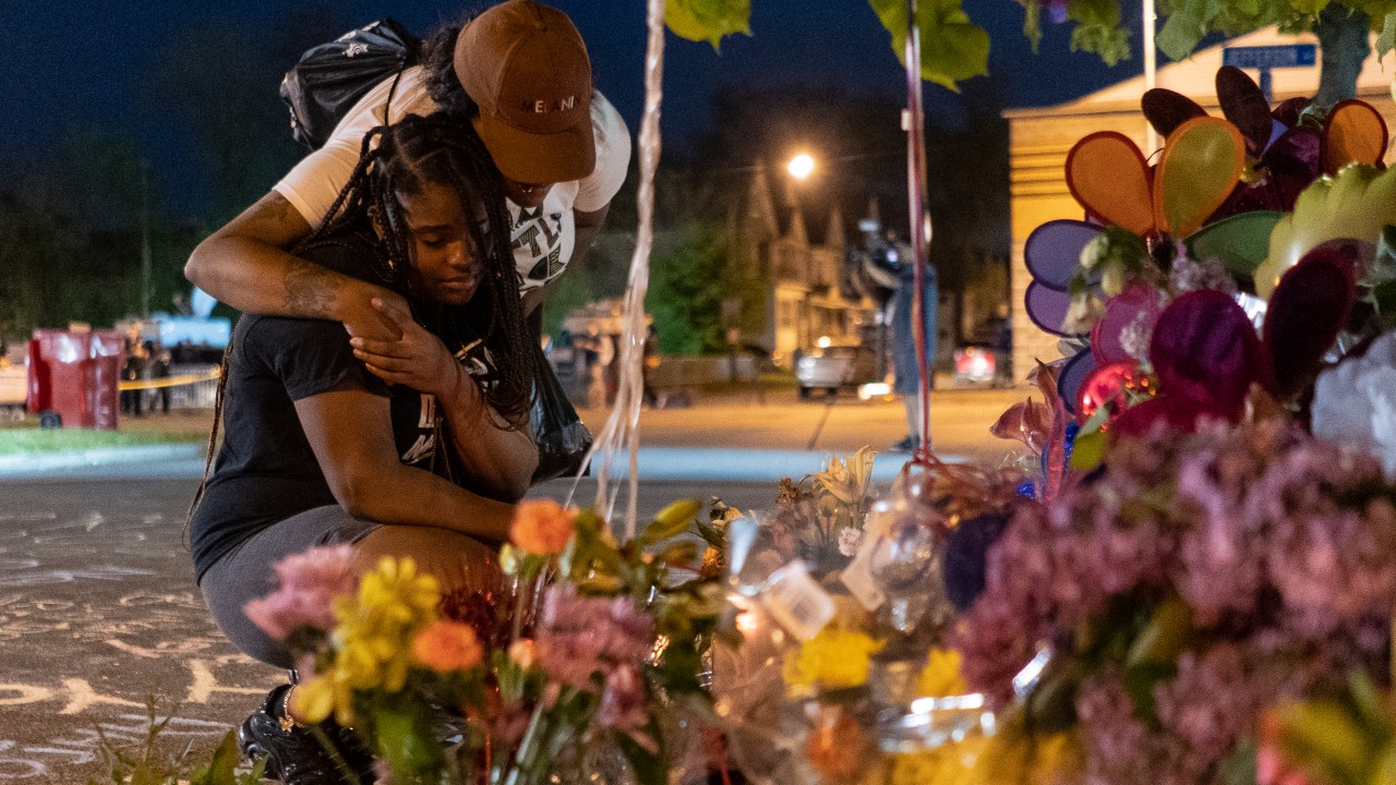 BUFFALO, NY - MAY 15: Pleazant Davis, 22, is comforted by her friend, Tasha Dixon, 35, at a memorial honoring the victims of the Tops shooting across the street from the store in Buffalo on May 15, 2022. If anybody wants to understand us, just be with us, Davis said. Dont just come around when tragedy happens in the Black community. () Its not always about food or water, its being here. Dont be afraid of us. Were the human race, we dont want to be separated more than the world is already making it seem. Davis and Dixon know one another through years of living in the area. We come together, we stick together, we stay together, said Davis simply. (Photo by Libby March for The Washington Post via Getty Images)