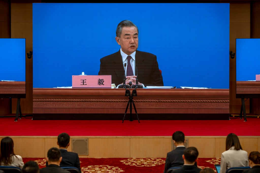 BEIJING, CHINA - MARCH 07: Chinese Foreign Minister Wang Yi is seen on large screens as he holds a press conference at the Media Center on March 07, 2022 in Beijing, China. (Photo by Andrea Verdelli/Getty Images