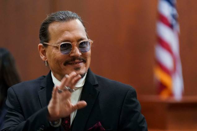 O ator Johnny Depp reconhece apoiadores, durante uma pausa em seu julgamento por difamação contra sua ex-esposa Amber Heard no Tribunal de Justiça do Condado de Fairfax em Fairfax, Virgínia, em 18 de maio de 2022.