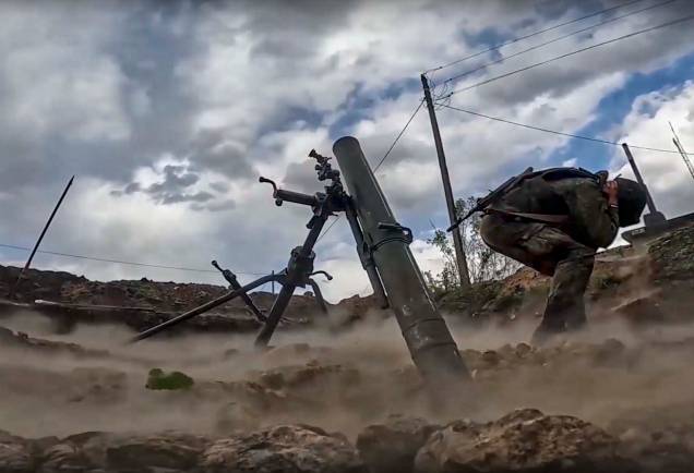Vídeo divulgado pelo serviço de imprensa do Ministério da Defesa da Rússia mostra um militar russo disparando um morteiro durante combates na região de Kharkiv, Ucrânia, 16 de maio de 2022.