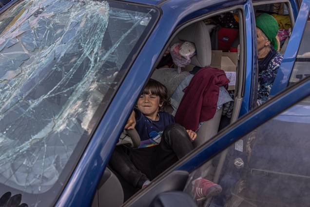 Zaporizhzhia, 02/05/2022.- Um menino brinca em um carro com uma janela quebrada depois de chegar de Mariupol no ponto de evacuação em Zaporizhzhia, Ucrânia, 02 de maio de 2022.