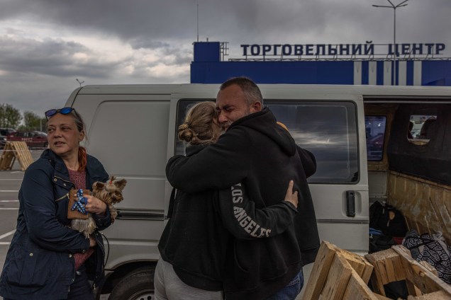 Pessoas se abraçam ao chegarem no ponto de evacuação em Zaporizhzhia, Ucrânia, 02 de maio de 2022. Milhares de pessoas, ainda estão em Mariupol e outras áreas do sul da Ucrânia, ocupada pelo exército russo.
