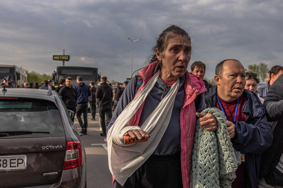 Uma mulher ferida, caminha após desembarcar de um ônibus que trouxe pessoas refugiadas da siderúrgica Azovstal, cidade de Mariupol e arredores para Zaporizhzhia, Ucrânia, 03 de maio de 2022.