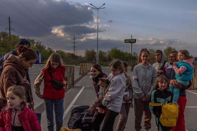 Famílias se reúnem, após chegarem da cidade de Tokmak, ocupada pelos russos, no ponto de evacuação em Zaporizhzhia, Ucrânia, 02 de maio de 2022.