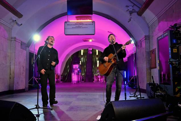 Bono (Paul David Hewson), cantor e compositor irlandês, ativista e vocalista da banda de rock U2, e o guitarrista David Howell Evans (R) aka 'The Edge', se apresentam na estação de metrô que é um abrigo antiaéreo, no centro da capital ucraniana de Kiev em 8 de maio de 2022.