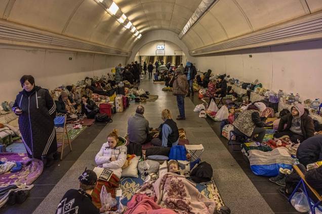 Pessoas dentro da estação de metrô Dorohozhychi, transformada em abrigo antiaéreo, em Kiev, Ucrânia.
