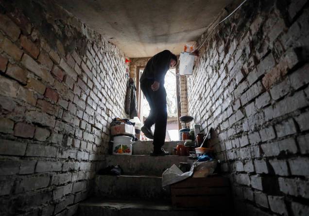 Morador local Nikolay (60), mostra a entrada de seu abrigo subterrâneo em casa destruída na vila de Kozarovychi, Ucrânia, 16 de maio de 2022.