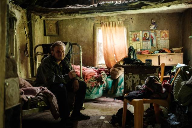 Um homem em sua casa sem eletricidade, abastecimento de água e rede telefônica em Lysychansk, leste da Ucrânia, em 15 de maio de 2022, em meio à invasão russa da Ucrânia.