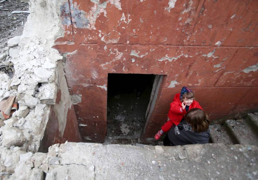 Moradores de Sievierodonetsk, Lugansk Oblast, seguem para o porão onde se abrigam, durante intensos bombardeios das forças russas e separatistas que apoiam.