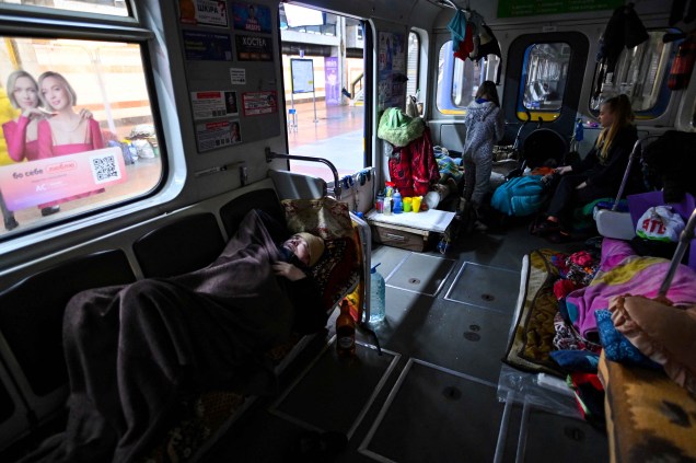 Um homem dorme em um vagão de metrô, numa estação usada como abrigo antiaéreo em Kiev.