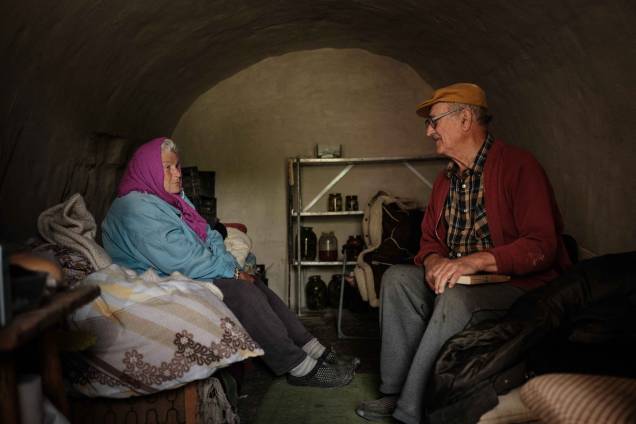 Um homem e sua esposa, conversam sentados em um abrigo em Sydorove, leste da Ucrânia, em 17 de maio de 2022.