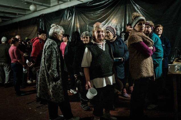 Pessoas aguardam distribuição de alimentos em um bunker de uma fábrica em Severodonetsk, leste da Ucrânia.