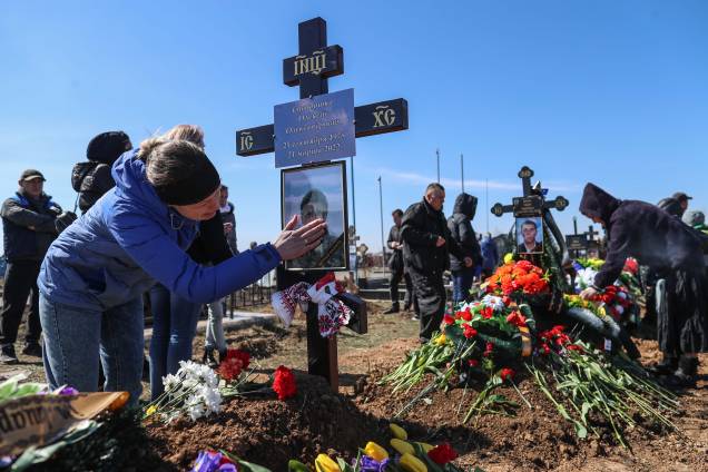 Familiares de um soldado ucraniano morto em Mykolaiv em um ataque aéreo russo assistem ao seu sepultamento no cemitério ocidental de Odessa, na cidade portuária de Odessa, no sul da Ucrânia, na Ucrânia, 28 de março de 2022.
