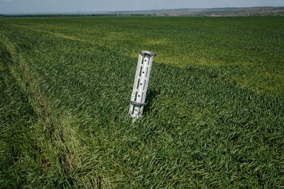 Foto tirada em 10 de maio de 2022 mostra os componentes internos de uma munição cluster em uma plantação, perto de Lysychansk, leste da Ucrânia, em meio à invasão russa da Ucrânia.