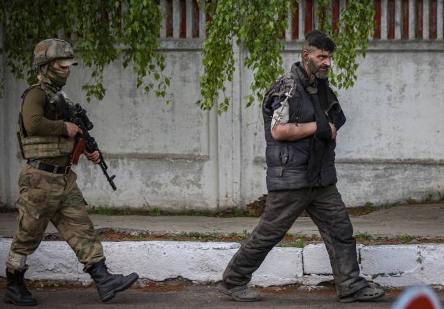 A autoproclamada milícia da República Popular de Donetsk, escolta um militar ucraniano da siderúrgica Azovstal sitiada em Mariupol, Ucrânia.