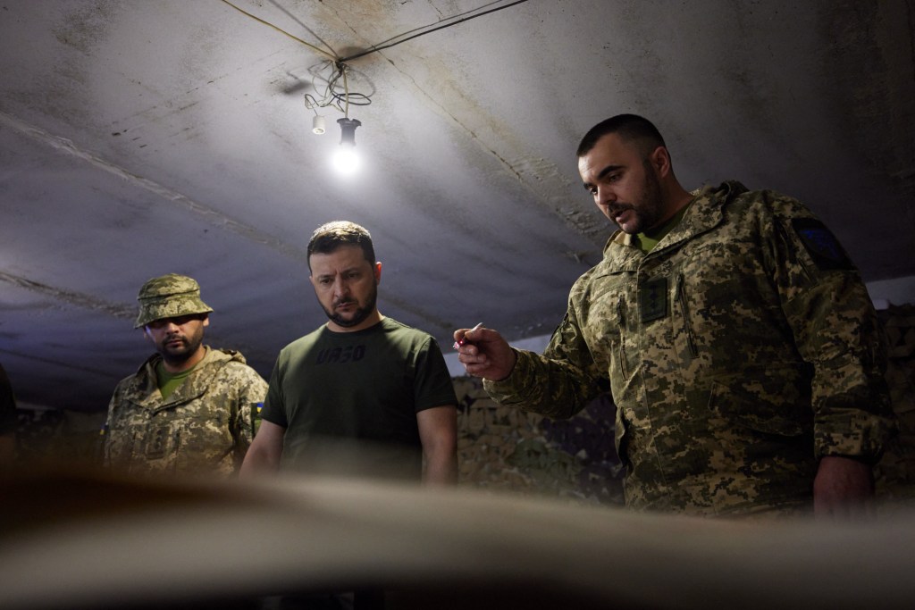 This handout picture taken and released by the Ukrainian presidential press service on June 5, 2022, shows Ukrainian President Volodymyr Zelensky (C) visiting the frontline positions of the Ukrainian military during a working trip to the Zaporizhzhia region. - The Head of State got himself acquainted with the operational situation on the frontline of defense. Volodymyr Zelenskyy talked to the servicemen and presented them with state awards and valuable gifts. (Photo by Handout / UKRAINIAN PRESIDENTIAL PRESS SERVICE / AFP) / RESTRICTED TO EDITORIAL USE - MANDATORY CREDIT "AFP PHOTO / UKRAINIAN PRESIDENCY " - NO MARKETING - NO ADVERTISING CAMPAIGNS - DISTRIBUTED AS A SERVICE TO CLIENTS