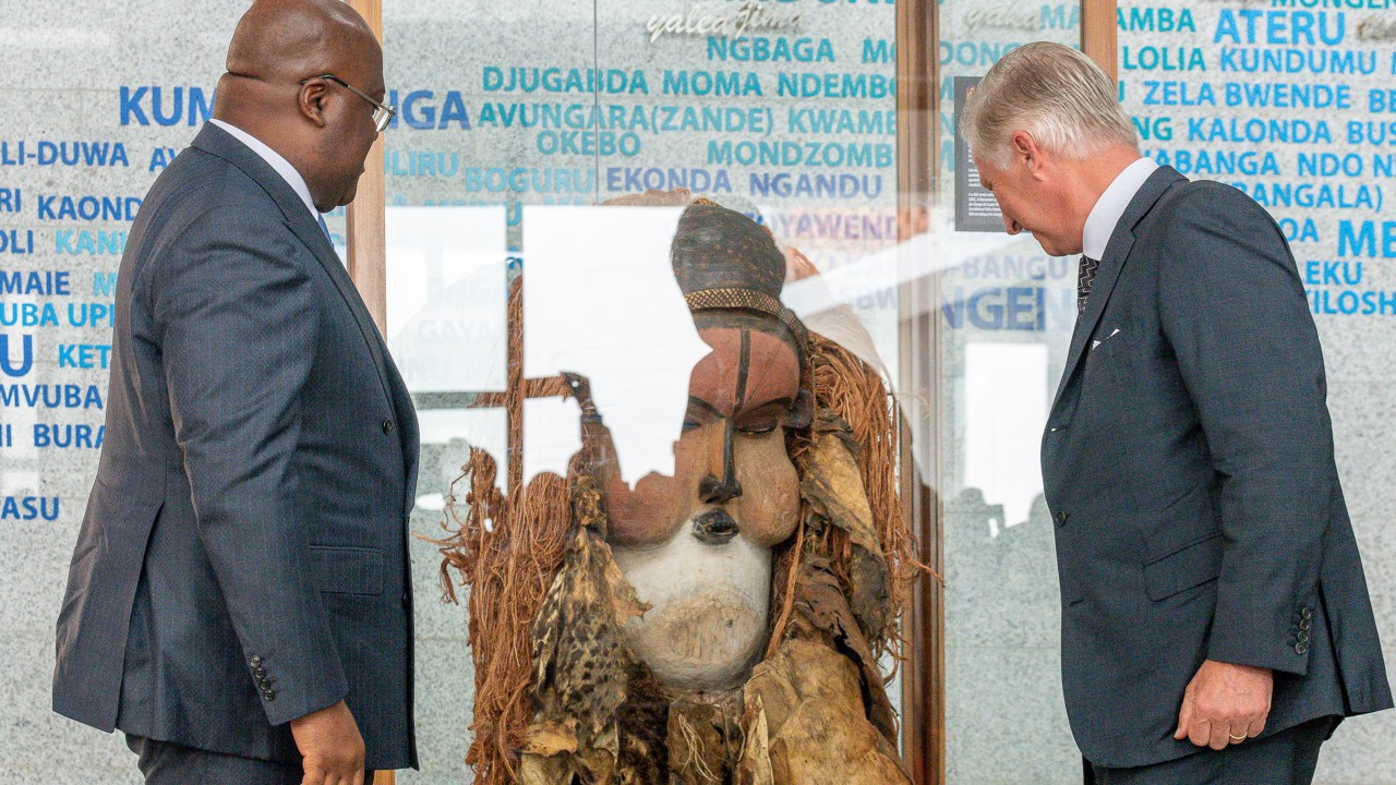 President of the Democratic Republic of the Congo Felix Tshisekedi (L) looks at a ceremonial mask handed over by Belgium's King Philippe (R) at the National Museum of the Democratic Republic of the Congo in Kinshasa on June 8, 2022. - Belgium's King Phillipe visited DRC's national museum in Kinshasa, established in 2019, where he handed over a ceremonial mask the ethnic Suku group use in initiation rites. The mask is on "unlimited" loan from Belgium's Royal Museum for Central Africa, he announced. The move comes after the Belgian government last year set out a roadmap for returning art works looted during the colonial era -- which remains a sensitive topic in DRC. (Photo by Arsene Mpiana / AFP)