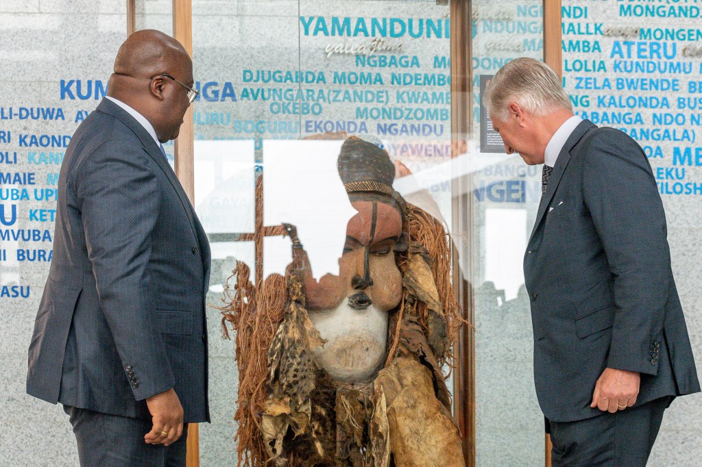 President of the Democratic Republic of the Congo Felix Tshisekedi (L) looks at a ceremonial mask handed over by Belgium's King Philippe (R) at the National Museum of the Democratic Republic of the Congo in Kinshasa on June 8, 2022. - Belgium's King Phillipe visited DRC's national museum in Kinshasa, established in 2019, where he handed over a ceremonial mask the ethnic Suku group use in initiation rites. The mask is on "unlimited" loan from Belgium's Royal Museum for Central Africa, he announced. The move comes after the Belgian government last year set out a roadmap for returning art works looted during the colonial era -- which remains a sensitive topic in DRC. (Photo by Arsene Mpiana / AFP)