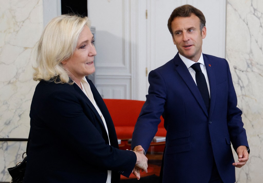 French far-right Rassemblement National (RN) leader and Member of Parliament Marine Le Pen (L) shakes hands with France's President Emmanuel Macron after talks at the presidential Elysee Palace, in Paris, on June 21, 2022, two days after France's legislative elections. - France's President Emmanuel Macron hosts political party chiefs in a bid to break the impasse created by the failure of his coalition to win a majority in parliamentary elections. (Photo by Ludovic MARIN / POOL / AFP)