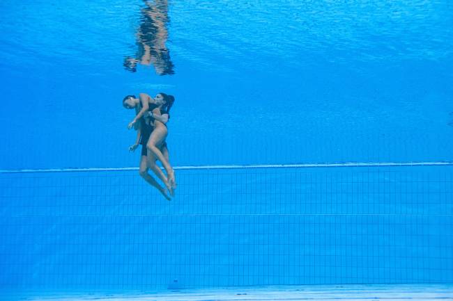 USA's Anita Alvarez is recovered from the bottom of the pool by a team member after an incendent, during the women's solo free artistic swimming finals during the Budapest 2022 World Aquatics Championships at the Alfred Hajos Swimming Complex in Budapest on June 22, 2022. (Photo by Oli SCARFF / AFP)