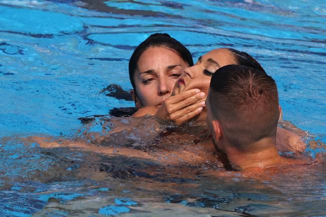 A member of Team USA (L) recovers USA's Anita Alvarez (C), from the bottom of the pool during an incendent in the women's solo free artistic swimming finals, during the Budapest 2022 World Aquatics Championships at the Alfred Hajos Swimming Complex in Budapest on June 22, 2022. (Photo by Peter Kohalmi / AFP)