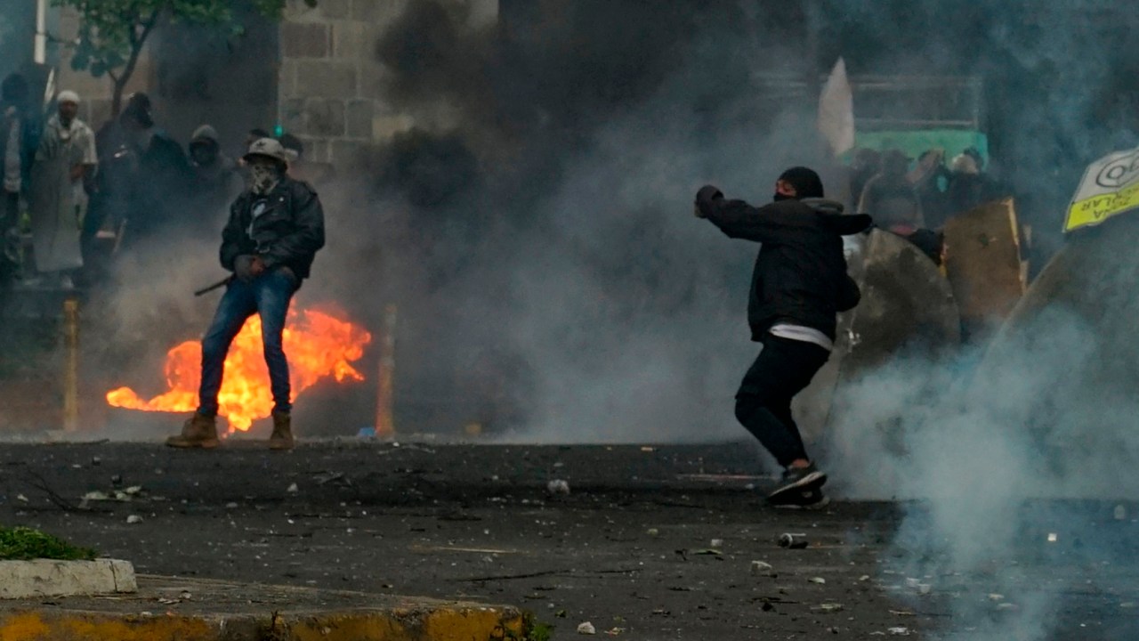 Demonstrators clash with the police in the surroundings of the House of Ecuadorean Culture in Quito, on June 22, 2022, on the tenth consecutive day of indigenous-led protests against the government. - Ecuador on Wednesday refused to end its state of emergency and said 18 police officers are "missing" following an attack by indigenous protesters on a police station in the eastern Amazon region. Two people died in clashes with law enforcement during indigenous-led fuel price protests that have triggered regional states of emergency and a curfew in the capital Quito. (Photo by Veronica LOMBEIDA / AFP)