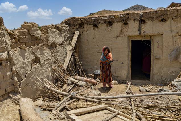 <span class="Y2IQFc">Uma criança fica ao lado de uma casa danificada por um terremoto na província de Paktika, Afeganistão. 23/06/2022.</span>