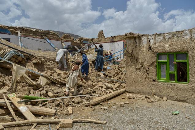 <span class="Y2IQFc">Afegãos procuram seus pertences em meio às ruínas de uma casa danificada por um terremoto no distrito de Bernal, província de Paktika. 23/06/2022. </span>