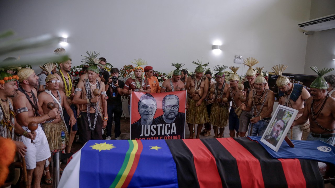 Xukuru¥s indigenous people sing a sacred pray in honor of the Brazilian indigenous expert Bruno Pereira next to his coffin during his funeral at the Morada da Paz Cemetery in Paulista, Pernambuco state, Brazil, on June 24, 2022. - The bodies of British journalist Dom Phillips and Indigenous expert Bruno Pereira were handed over to their families Thursday, nearly two and half weeks after they were killed in Brazil's Amazon. Phillips, 57, and Pereira, 41, were shot while returning from an expedition in the Javari Valley, a remote region of the rainforest. (Photo by BRENDA ALCANTARA / AFP)