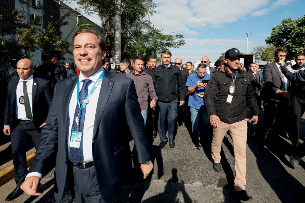 HÚBRIS - Guimarães em evento com Bolsonaro (ao fundo): alvejado por denúncias de abusos na Caixa -