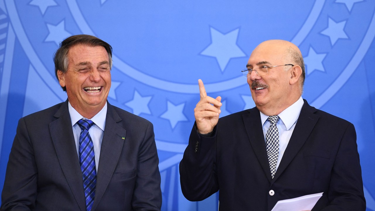(FILES) In this file photo taken on February 4, 2022, Brazilian President Jair Bolsonaro (L) and his Education Minister Milton Ribeiro gesture during a ceremony in which the salaries of teachers of elementary education were increased, at Planalto Palace in Brasilia. - The Brazilian justice ordered on June 22, 2022, the arrest of Milton Ribeiro, former Minister of Education of the far-right president Jair Bolsonaro, for alleged corruption and influence peddling to favour allies of Evangelical pastors with public resources, confirmed the Federal Police (PF). Ribeiro had presented his resignation in March after newspaper Folha de Sao Paulo revealed an audio recording of him saying he gave priority in deciding school-funding requests to municipalities governed by political allies of influential Evangelical pastors at the far-right president's request. (Photo by EVARISTO SA / AFP)